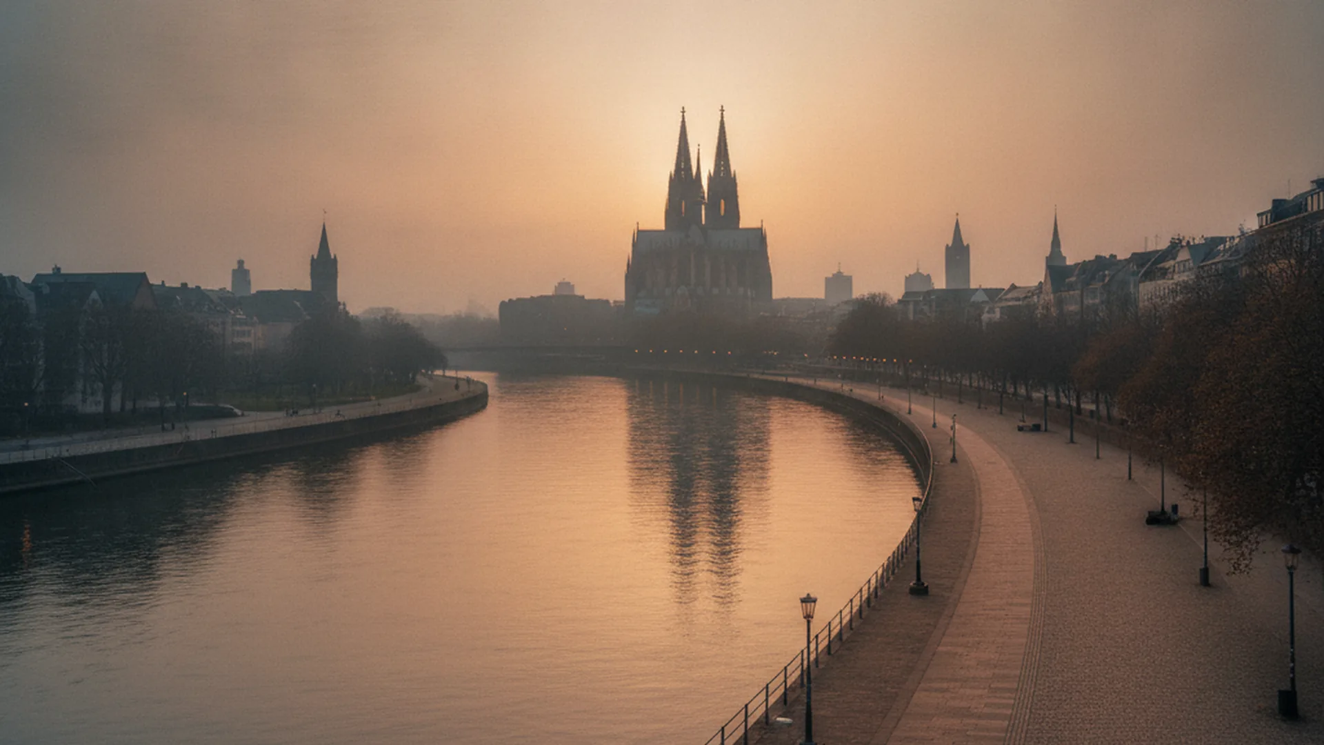 Die Elbe fließt am Abend durch Magdeburg mit Domsilhouette am Ufer — sinnbildlich für den Wirtschaftsstandort an der Elbe